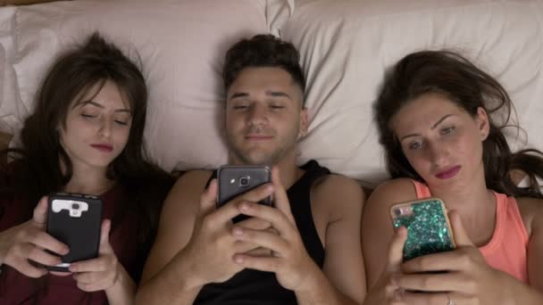 Baum Teenager Freunde entspannt im Bett verbringen Zeit im Internet surfen auf ihren Smartphones Technologie-Sucht — Stockvideo