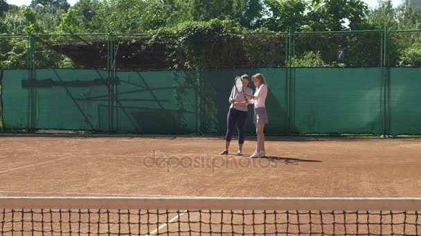 Тренер учит теннисиста держать ракетку и подавать — стоковое видео