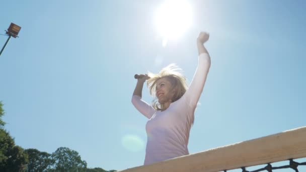 Евфорическая женщина счастливо прыгает с теннисной ракеткой в руке, празднуя победу — стоковое видео