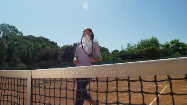 Женщина теннисистка прибегает к филе и делает жест триумфа после матча — стоковое видео