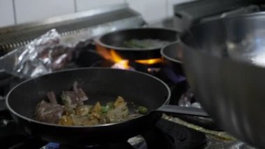 Genç Şef kuzu et ve lüks restoranda bir tavada ocakta egzotik sebze yemek