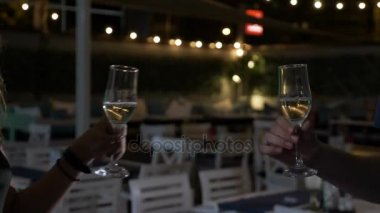 Gülümseyen bir kadeh şampanya ile genç adam ve kodes gözlük toasting sarışın kadın