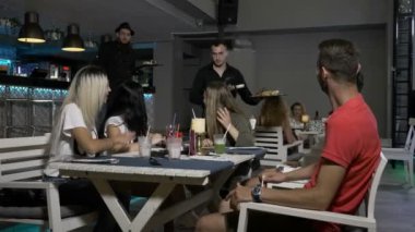 Masada oturan ve şefler tarafından bir restoranda egzotik yemek yemekler sunulmakta kokteyl içme arkadaş