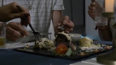 Tatlı adam et plaka üzerinde kesme ve onun kız arkadaşı bir restoranda tatmak için sunan