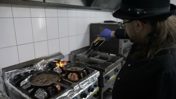 两个男厨师在锅里充分加入酒中餐厅厨房烹饪美味的肉和蔬菜组合的恐 — 图库视频影像