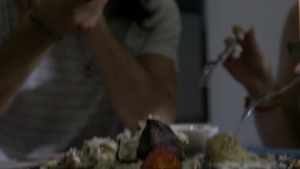 Junger Mann mit Bart und langen Haaren isst mit Freunden leckeres Gericht, zubereitet von erfahrenem Koch — Stockvideo