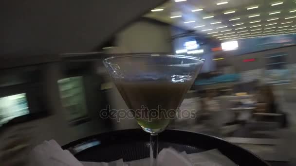 Waiter bringing flaming cocktail to a group of young friends sitting on table relaxing and chatting — Stock Video