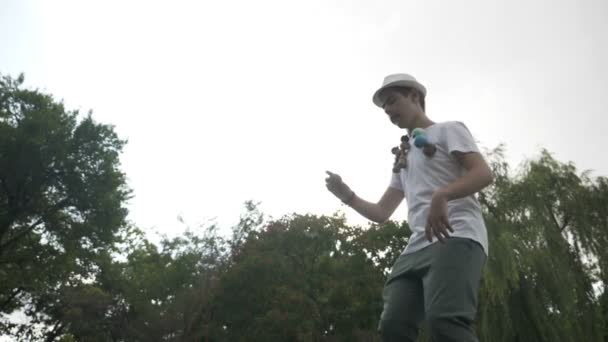 Mouvement lent de kendama maître joueur tourbillonnant jouet dans l'air montrant un tour compliqué dans le parc — Video