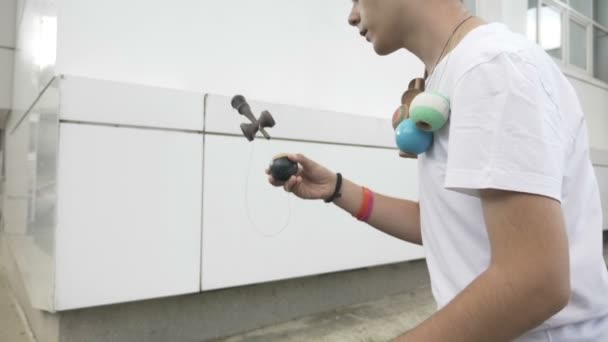 Adolescente exercitando talento por pegar bola kendama em movimento lento de pico — Vídeo de Stock