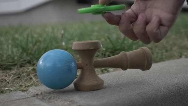 Concepto de juguetes más populares para niños y adultos kendama y spinner en cámara lenta — Vídeo de stock