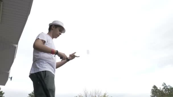 Closeup of cool kid in short white pants performing swirl stall and lighthouse kendama tricks — Stock Video