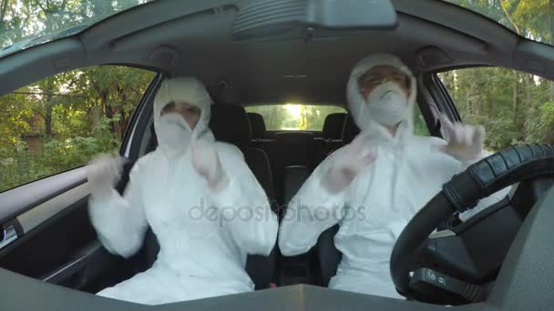 Funny concept of two young hazmat scientists workers in car dancing and driving to contaminated location — Stock Video