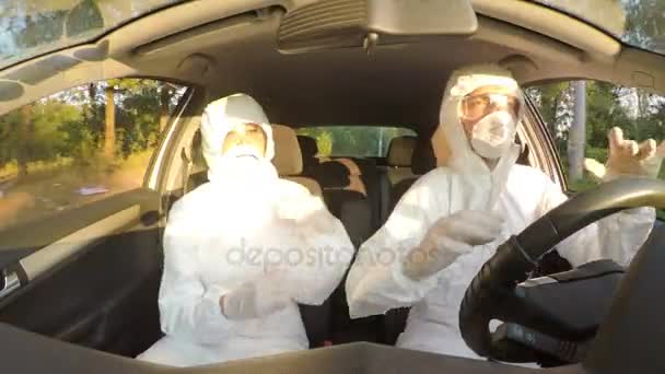 Jubelnde Wissenschaftler im Warnanzug tanzen und haben Spaß bei der Arbeit im Auto, während sie zum ansteckenden Feld fahren — Stockvideo
