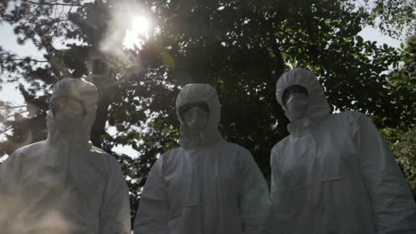 Hazmat technician engineers workers covered with protection clothing and mask standing still contaminated by toxic gas smoke — Stock Video