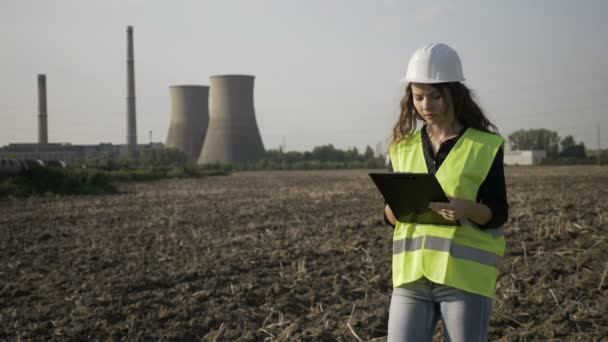 Endüstriyel faaliyet hakkında notlar alarak site inşaat Emanet iş teftiş ile görevli genç bir mühendis kadın — Stok video