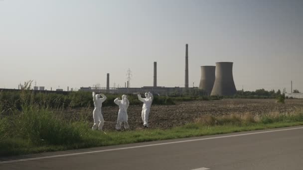 Crazy hazmat team av arbetstagare dansande nära ett kärnkraftverk växt roliga begreppet ekologi — Stockvideo