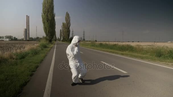 Contaminated ecologist worker in hazmat suit chocking and falling down on drive way near refinery and dying — Stock Video