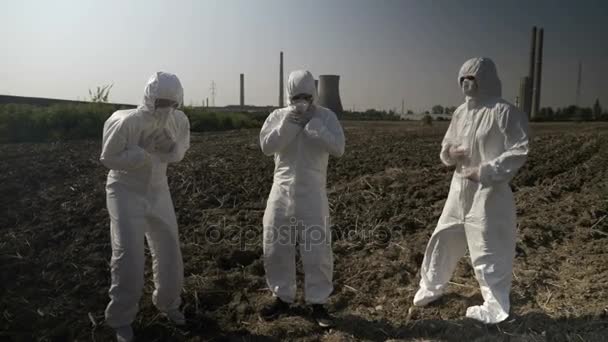 Ingénieurs habillant vêtements dangereux de protection intoxiqués avec des déchets nucléaires de près d'une centrale électrique tombant en panne mourant — Video