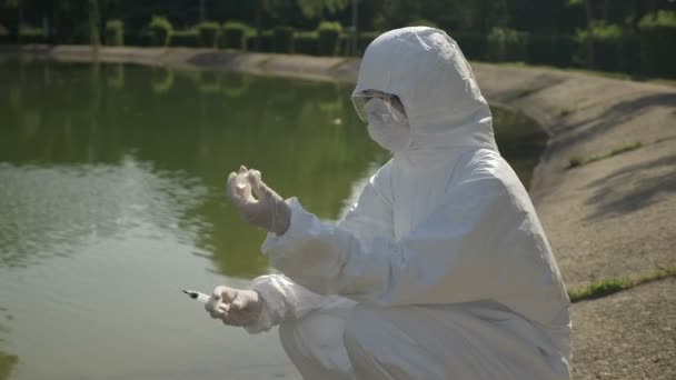 Biologe injiziert einen Katalysator in eine verunreinigte Wasserprobe zur Untersuchung der chemischen Wirkung — Stockvideo