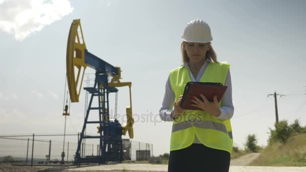 Piękny engineering oceniającego kobieta pracuje nad jej cyfrowego tabletu w przemyśle naftowym zadowolony przez jej zadanie — Wideo stockowe