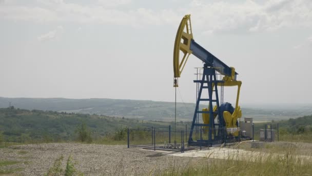 Vackra landskapet kullar med pumpjack utvinna olja — Stockvideo