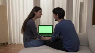 Çekici genç kadın gözlüklü sevgilisi online alışveriş yapmak için ikna etmeye çalışıyor