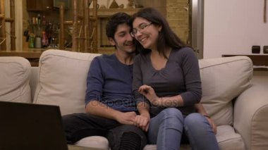 Pazar gecesi bir dizüstü evde komedi film izlerken sevgilisi kucağında oturan sevgi genç kadın