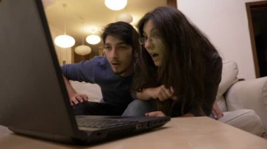 Güzel genç çift balayı egzotik hedef videoları laptop oturma odasında izlerken heyecanlı