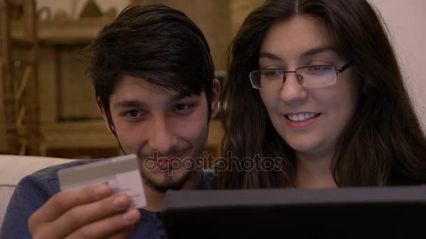 Donna sorridente che introduce i dati della carta di credito per fare acquisti online da casa — Video Stock