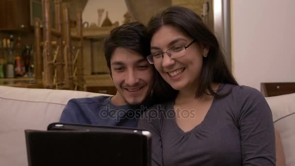 Gelukkige affectieve paar zittend op de Bank bij home video oproep chatten met ouders en vrienden zwaaien op tablet pc — Stockvideo