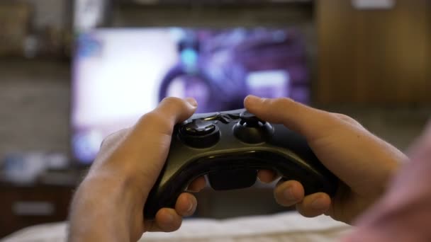 Jeune homme accro aux jeux vidéo tenant manette de jeu jouant à la première personne jeu de tir console — Video