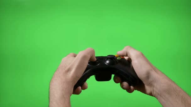 Hands of dedicated young gamer using a game controller with green screen in background — Stock Video