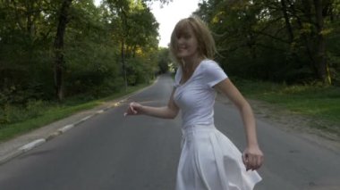 Bir orman yolu üzerinde çalışan ve gülümseyen güzel sarışın çekici kadın