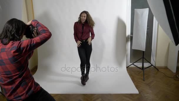 Séance photo au ralenti d'une célébrité dans un studio d'arrière-plan blanc professionnel pour une couverture de magazine féminin — Video