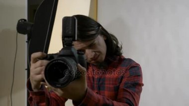 Kamera fotoğraf seanstan önce kontrol profesyonel bir stüdyoda iş yerinde ilk gününde siyah saçlı genç fotoğraf öğrenci