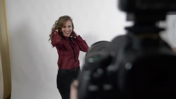 Point de vue du photographe faisant campagne célèbre de la marque de vêtements séance de photo en studio avec un modèle féminin au ralenti — Video