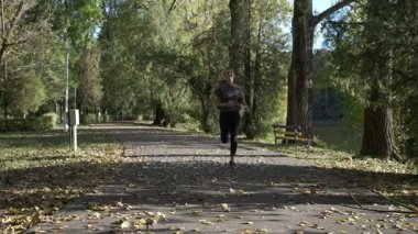 Yalnız vücudu yavaş sonbahar güneşli formda kalmaya koşu ve Şehir Parkı içinde terleme mutlu fitness kadın