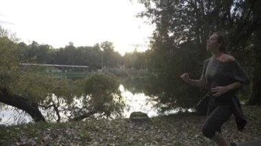 Vücudu sesi ve yavaş hareket dayanıklılığı artırmak için parkta koşu atletik kadın öğretim üyesi