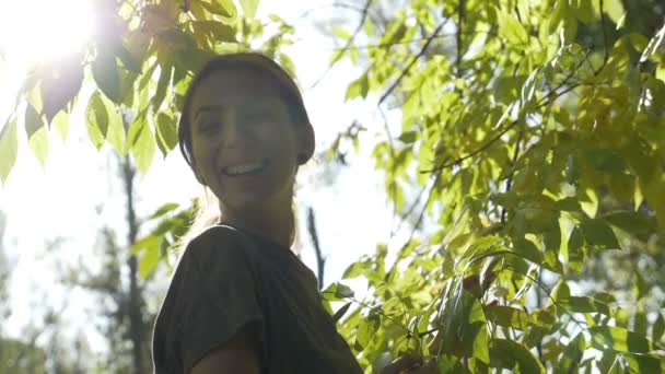 Gelukkig jonge vrouw dragen sport kleren glimlachend en genieten van het geel en groen vertrekt vanuit een park op een warme herfstdag in slow motion — Stockvideo