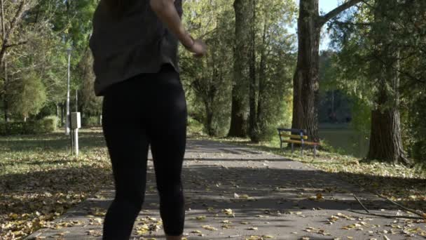 Treinamento de modelo feminino de fitness alto atraente em um parque de lago em um belo fim de semana de outono em câmera lenta — Vídeo de Stock