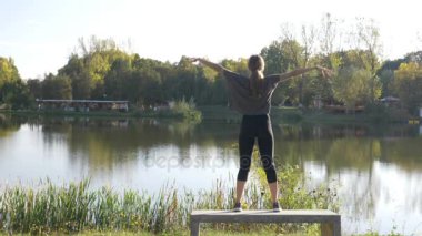Teneffüs edilmesi ve exhaling çekici kızı bir güzel yaz günü uzanan bir parkta yoga yaparken