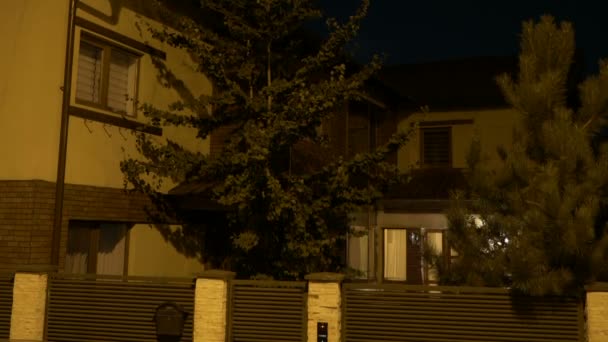 Mise en place plan de la cour de la maison extérieure avec des lumières allumées dans chaque pièce à partir de zéro sol la nuit — Video