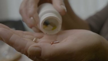 Takviyeler ve vitaminler bir bardak su evde onlarla yutma onun elinde bir şişe boşalma büyükanne