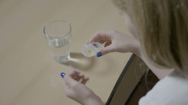 Belle modèle féminin commençant la journée avec une pilule vitaminée et un verre d'eau avant d'aller au travail — Video