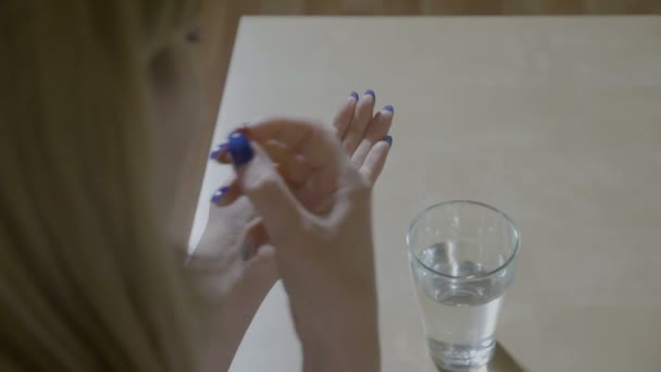 Ofiste hastalığı tedavi etmek için iki farklı antibiyotik kapsül ve içme suyu yutma hasta sarışın kız — Stok video