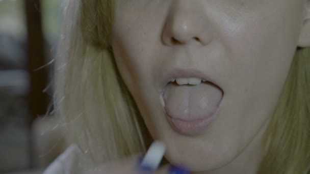 Close up of a blonde woman mouth swallowing an aspirin pill at home to cure flu fever and muscle spasm — Stock Video