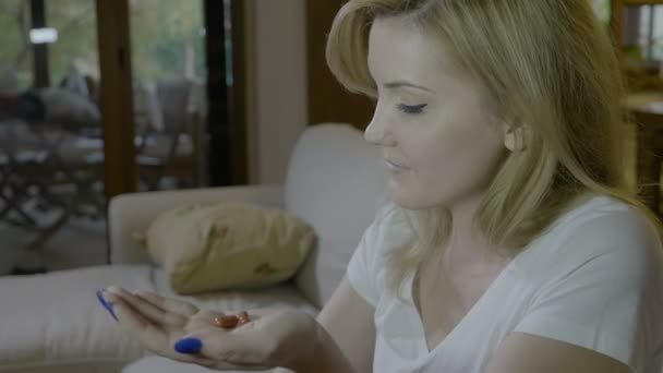 Joven periodista atractiva mujer tragar dos píldoras antibióticos con un vaso de agua una cápsula a la vez en casa — Vídeos de Stock
