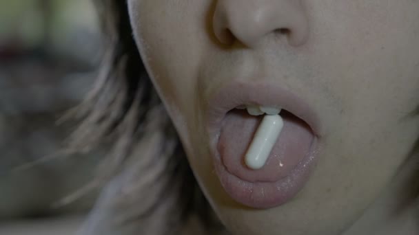 Close up of a man young male patient swallowing a capsule of antibiotic and drinking a glass of water after it — Stock Video