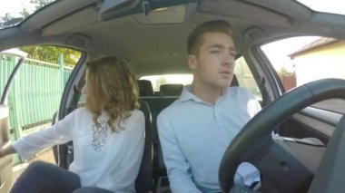 Genç adam ve kız arabaya bin ve terk etmek ve kendi emniyet kemeri tak hazırlamak ve o aynaya bakar