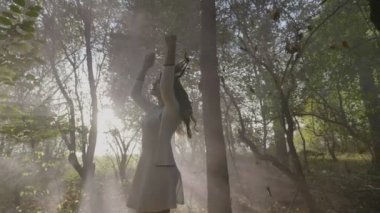 Parkta düşen sonbahar yaprakları ve duman yavaş hareket arasında eğlenmek basit beyaz elbise ile güzel genç gelin